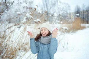 happy-young-woman-throwing-snow-up-air-sunny-winter-day_80942-217
